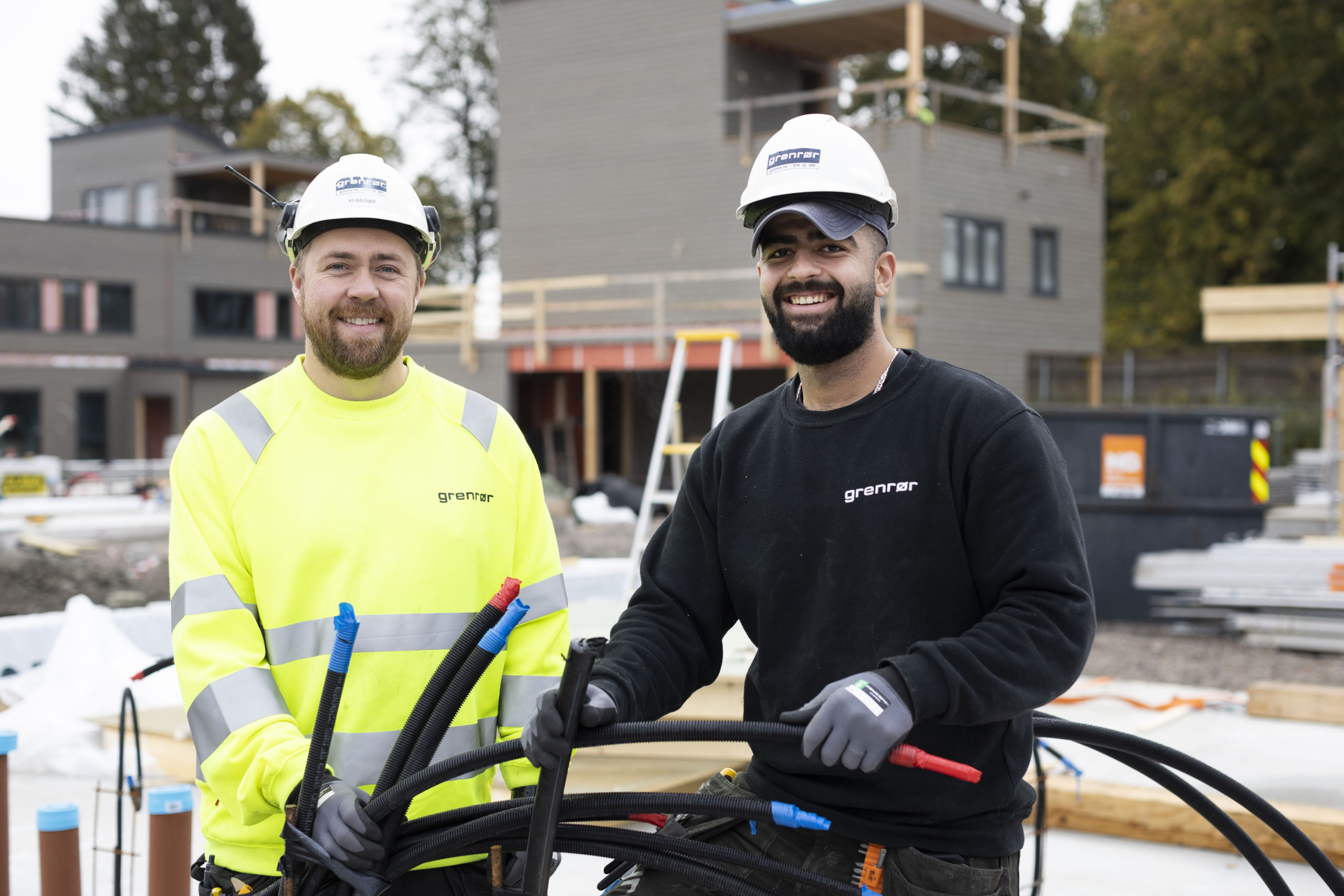 Foto av to elektrikere med ledninger på byggeplass.